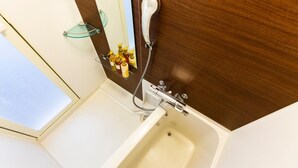 A bathroom with a bathtub, a glass shower enclosure, and a mirror. - Mr. Kinjo In Maehara (Ginowan)