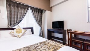 A hotel room with a bed, a desk with a TV, and a chair. - Mr. Kinjo In Maehara (Ginowan)