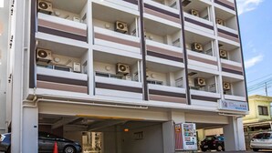A multi-story hotel with air conditioning units on each floor, a parking garage entrance, and a vending machine. - Mr. Kinjo In Maehara (Ginowan)