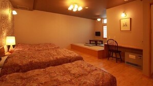Une chambre avec deux lits, un bureau, une chaise et un téléviseur.