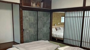 Et traditionelt japansk værelse med tatamimåtter, lavt loft og skydedøre.