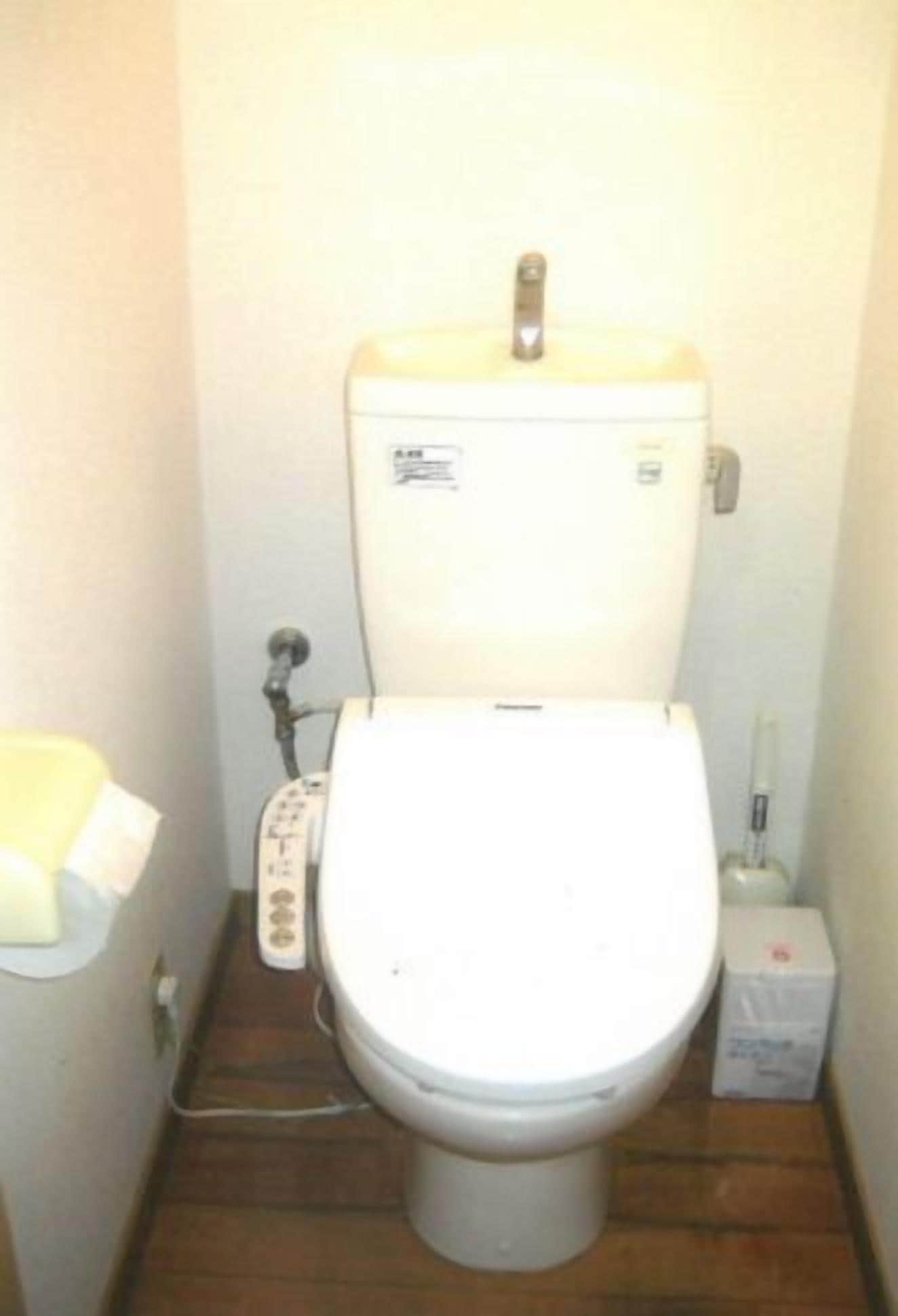 Un baño pequeño y funcional con inodoro, bidé y secamanos.