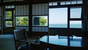Ein traditioneller japanischer Raum mit Tatami-Boden, einem niedrigen Tisch und Schiebetüren.