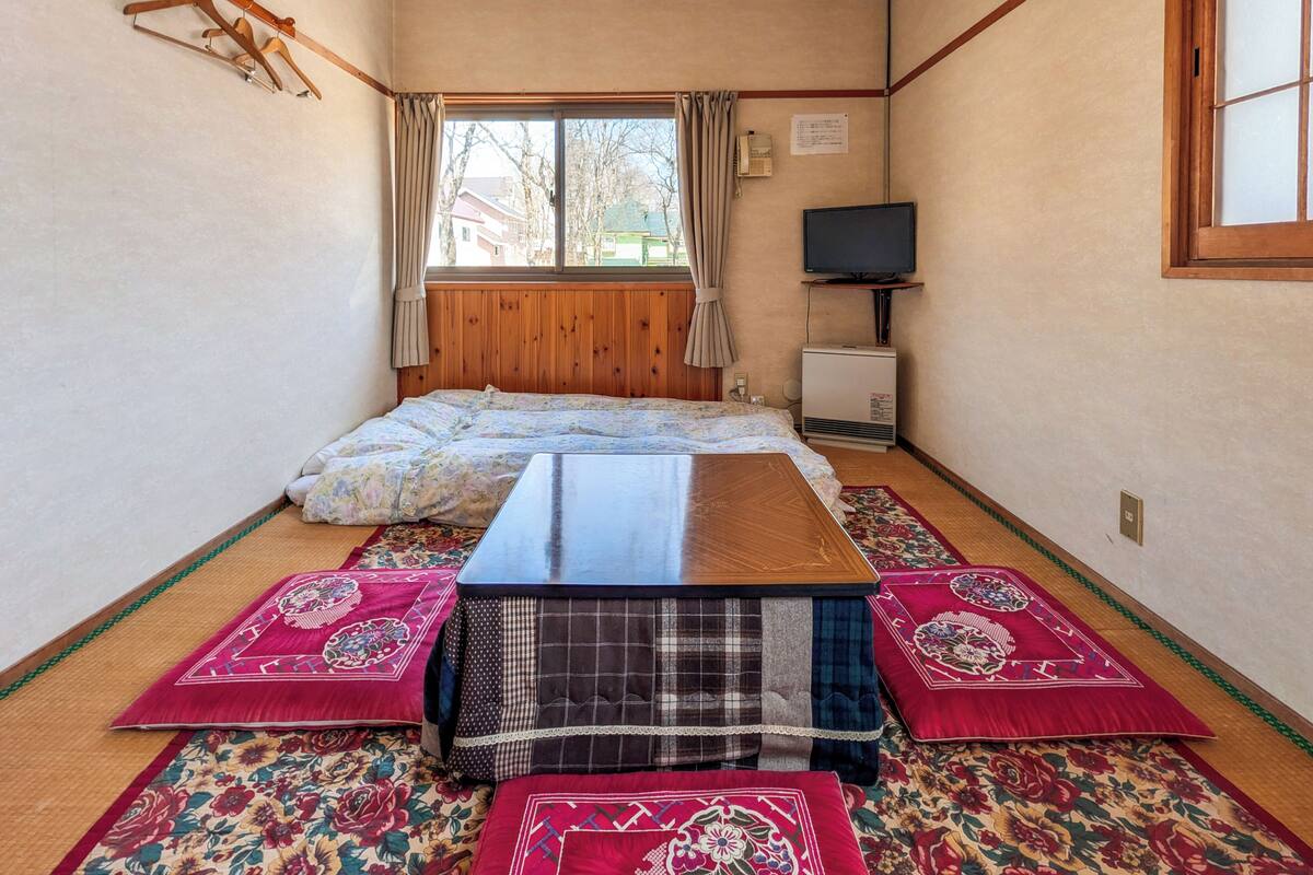 Une chambre avec un lit, une télévision et un plafond en bois.