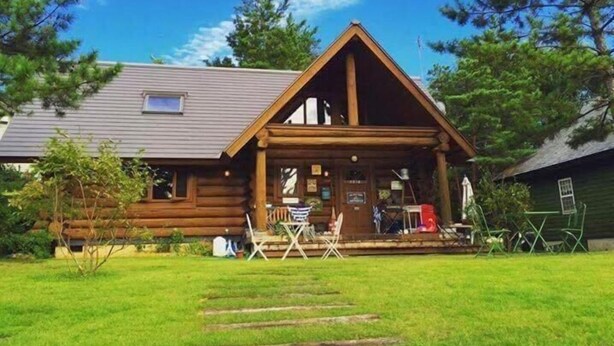 A log cabin with a porch, a small deck, and a grassy yard. - Dejavu (Shika)