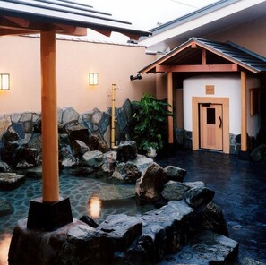 A traditional Japanese-style building with a stone courtyard, a wooden structure, and a wooden door. - Hotel Route-inn Utsunomiya Miyukicho-kokudou4gou- (Utsunomiya)