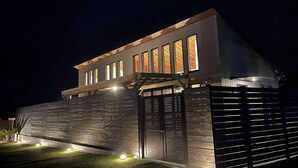 A modern house with a sloped roof, large windows, and a wooden fence. - Kyoran Fukatei (Tateyama)