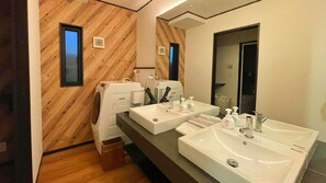 A modern bathroom with wooden wall paneling, two sinks, a mirror, and a washing machine. - Kyoran Fukatei (Tateyama)