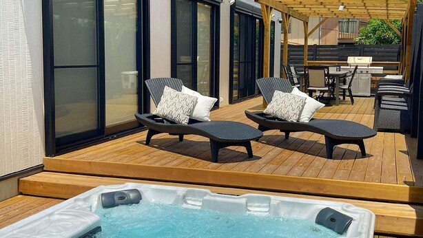 A rooftop patio with two lounge chairs, a hot tub, and a dining area. - Kyoran Fukatei (Tateyama)