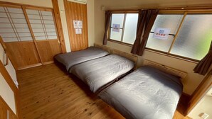 A room with two beds, wooden flooring, a sliding door, and frosted windows. - ARS Hotel Nikko/imaichi (Nikko)