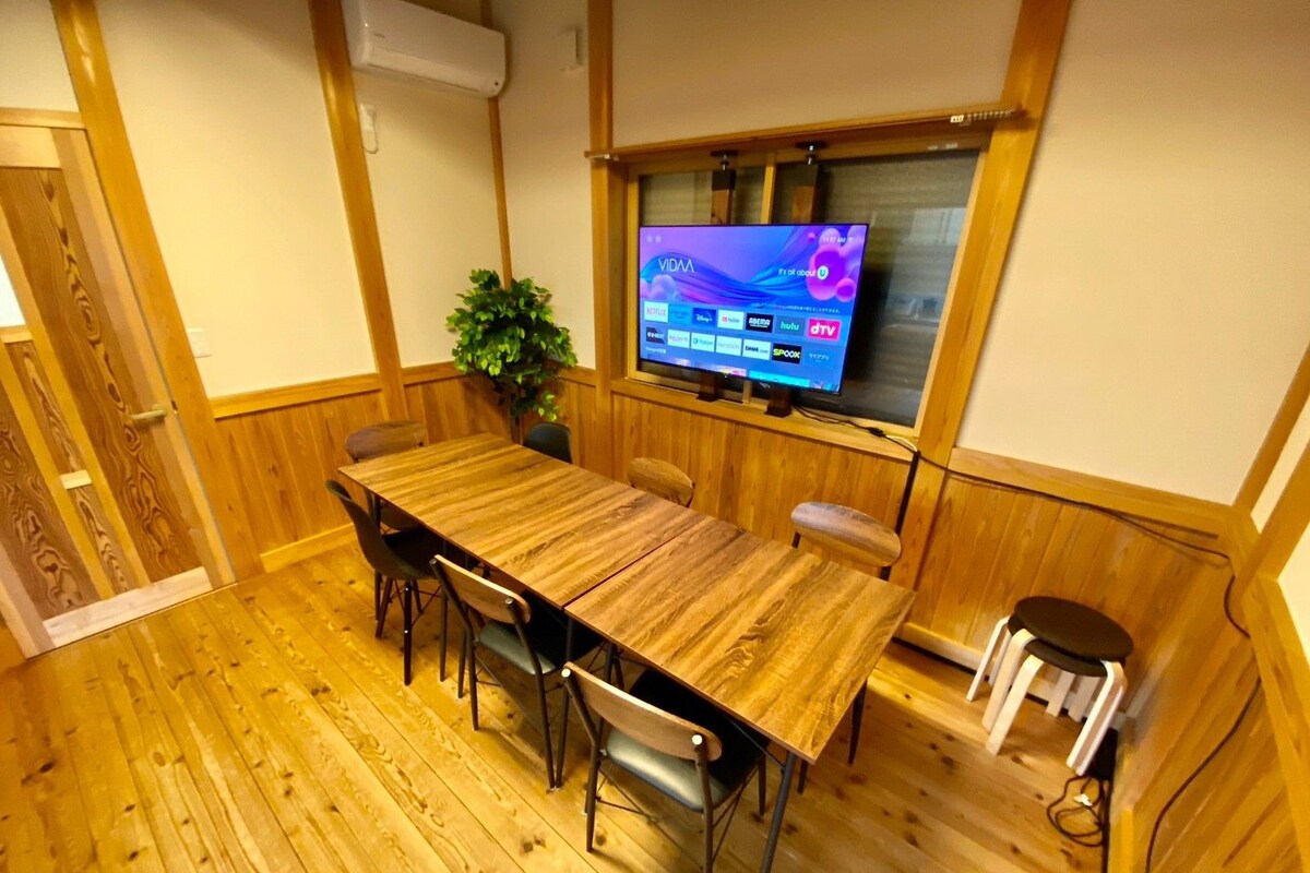 A wooden-paneled room with a TV mounted on the wall displaying a program.