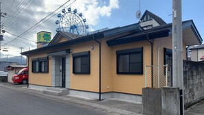 A two-story building with a yellow facade, a black roof, and a visible entrance with a door and windows. - ARS Hotel Nikko/imaichi (Nikko)