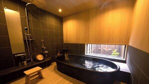 Une salle de bain moderne avec une baignoire sur pieds, une douche et une fenêtre offrant une vue.