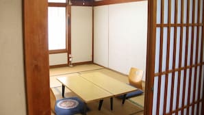 A traditional Japanese room with tatami flooring, a low table, and a sliding door. - Annex Kawanatsu (Shinonsen)