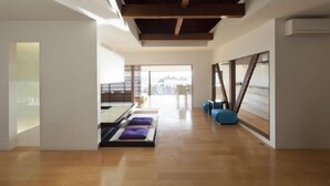 Ein modernes Interieur mit Holzboden, einer Glastrennwand und Blick ins Freie.