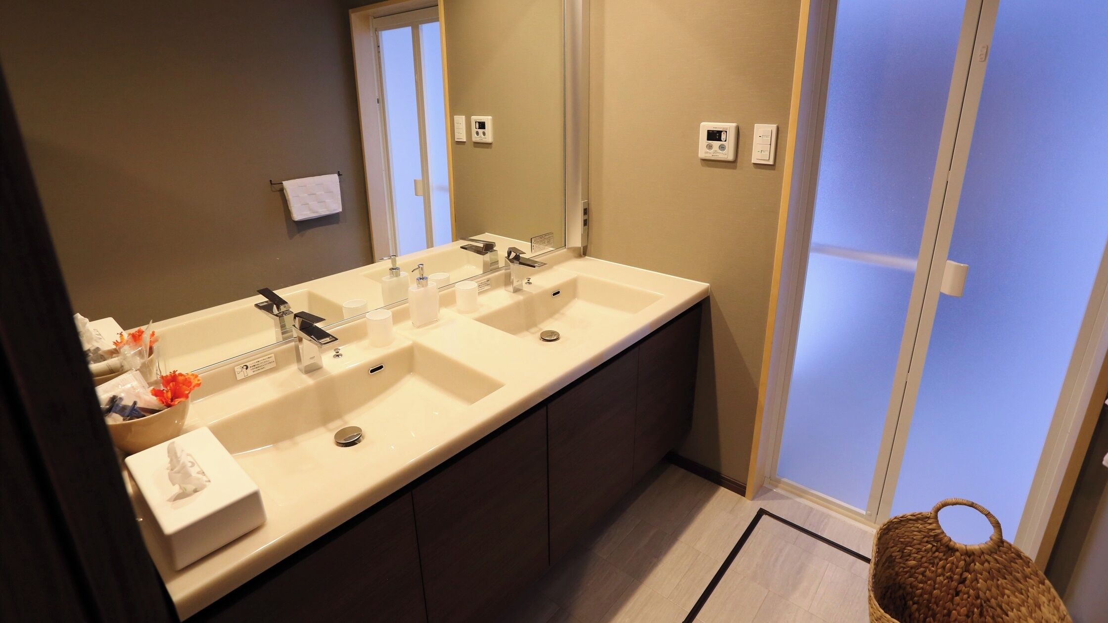 Une salle de bain moderne avec un double vasque, un miroir et un porte-serviettes.