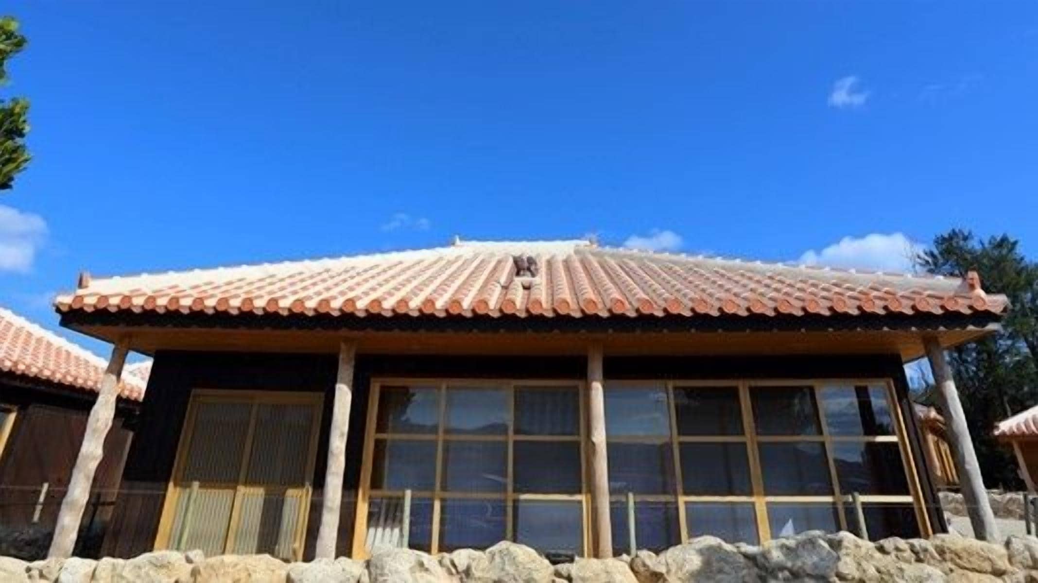 A traditional building with a tiled roof and large windows.