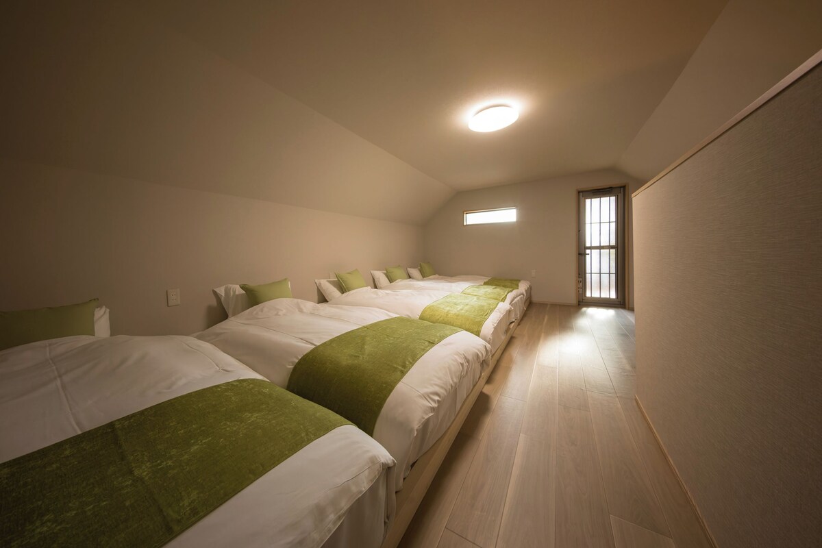 A hotel room with a sloped ceiling, a skylight, and a wooden floor.