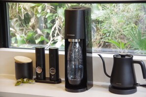 A kitchen counter with a coffee maker, a kettle, and two thermos flasks. - The Canvas Hayama Park (Hayama)