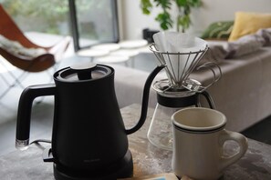 Une cuisine avec une machine à café, une tasse et un récipient en verre posés sur une table.