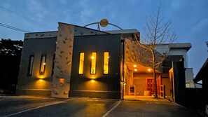 Un edificio con architettura moderna, caratterizzato da un ingresso ben visibile con una porta in vetro e un cartello sopra.