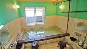 Pequeño cuarto con piso de baldosas, una bañera, un ventanal y zona de ducha.