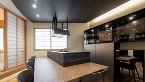 Una cocina moderna con una isla central, armarios negros y un ventanal grande.