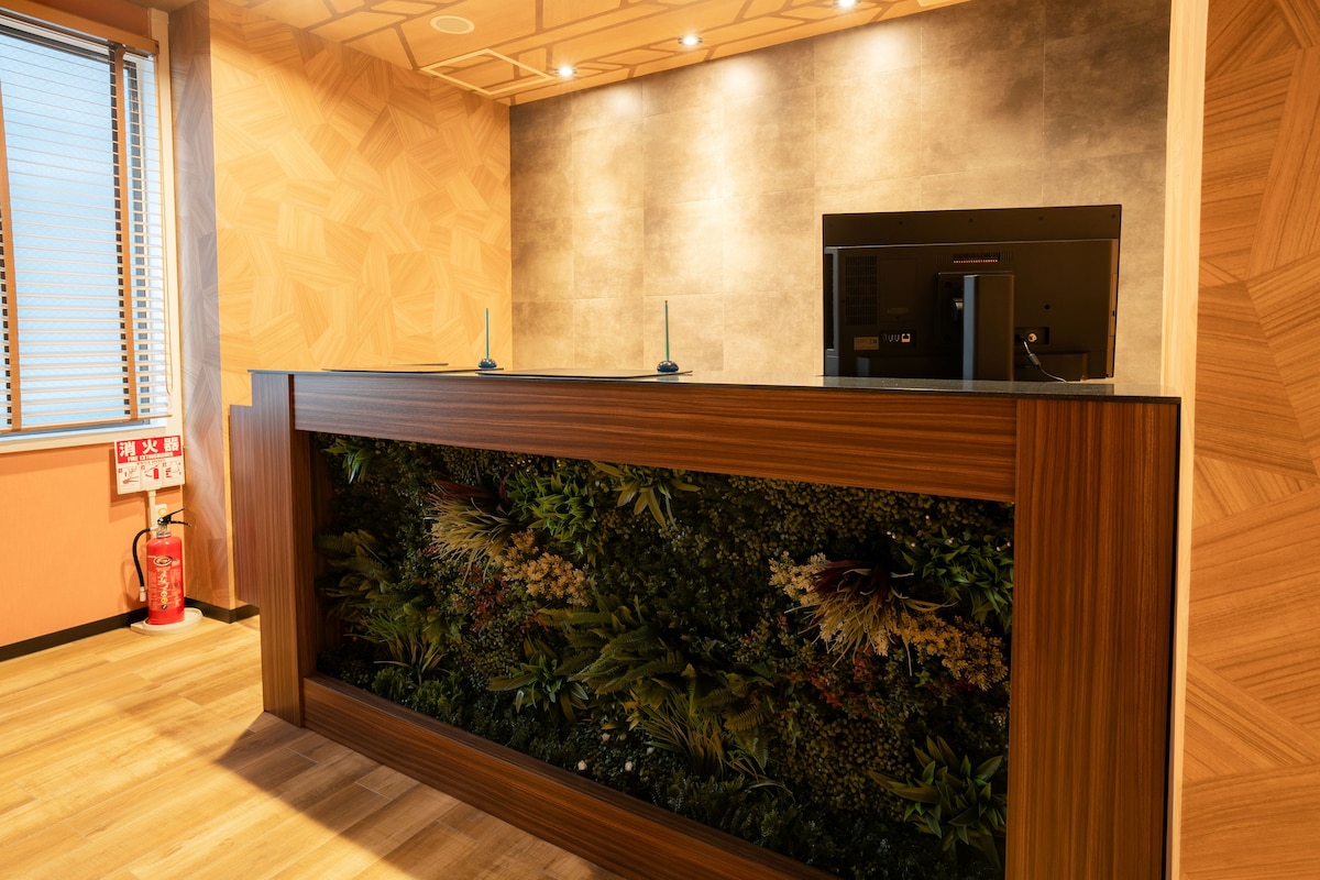 A reception desk with a built-in aquarium, wooden flooring, and a fire extinguisher.
