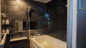 A modern bathroom with a freestanding bathtub, a glass shower enclosure, and a built-in vanity with a mirror. - Ping Pong Hotel & Cabin Tokuyama Ekimae / Ping Pong Residence Kojimachi (Shunan)