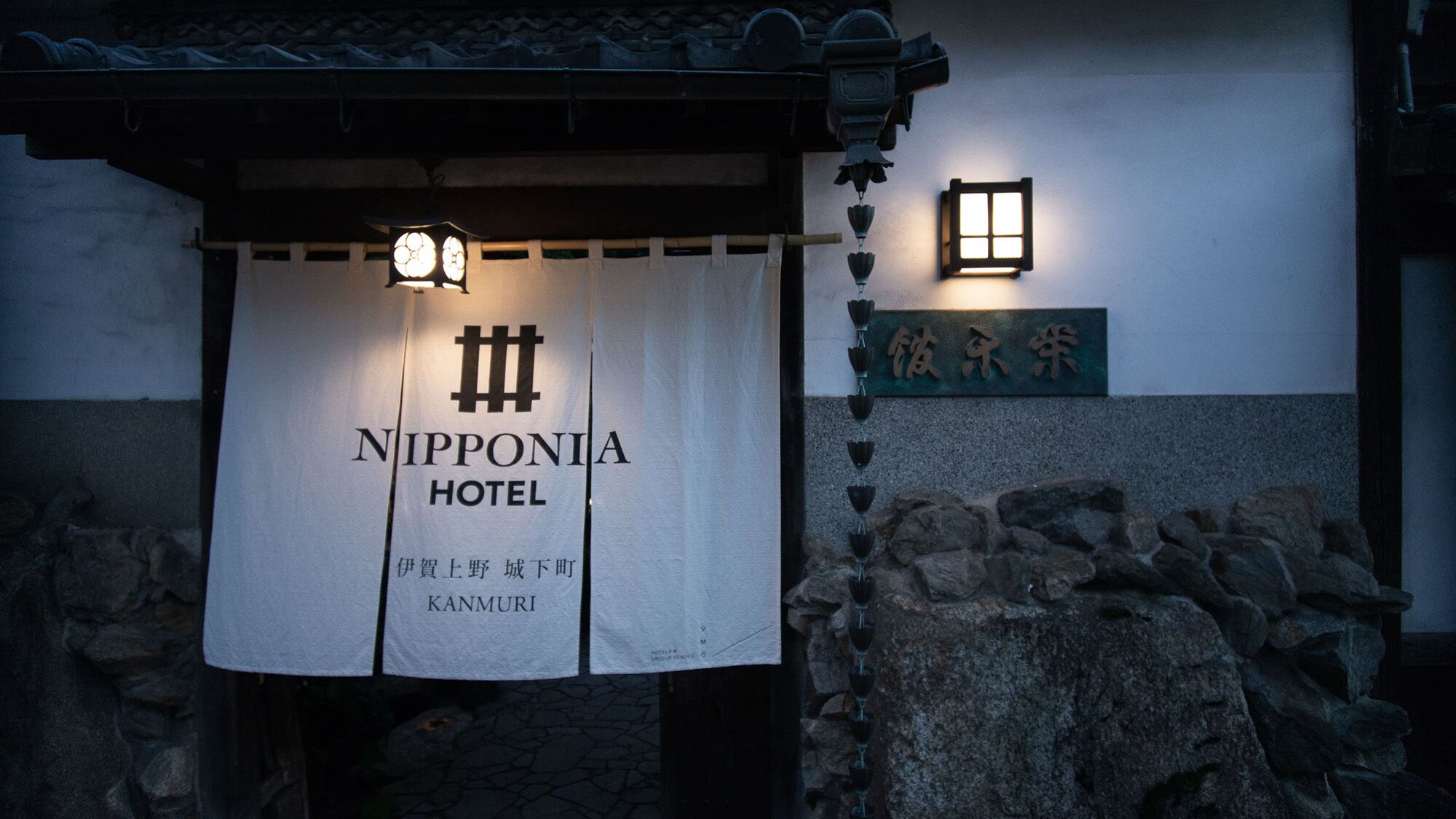 Señal del Hotel Nipponia, con un farol y un muro de piedra.