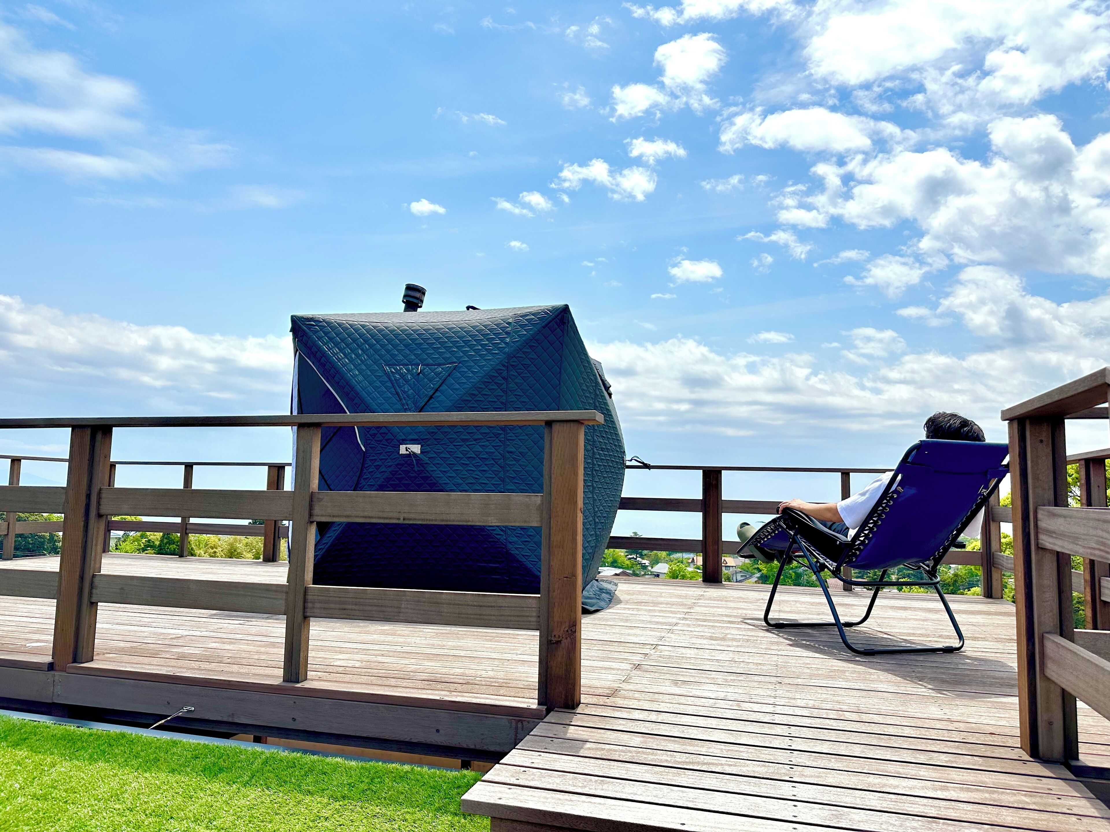 A wooden deck with a covered seating area and a person playing an accordion.