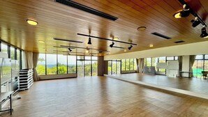 Une pièce spacieuse dot ée d’un plancher en bois, de grandes fenêtres et de luminaires au plafond.
