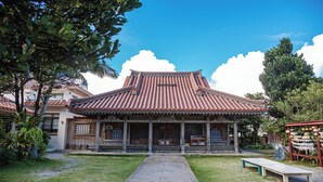A traditional building with a tiled roof, a central entrance with steps, and a surrounding garden. - Hotel Fit In Ishigakijima (Ishigaki)