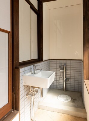 A bathroom with a white sink, a shower, and tiled walls. - Kohaku Amber Kamakura Zaimokuza (Kamakura)