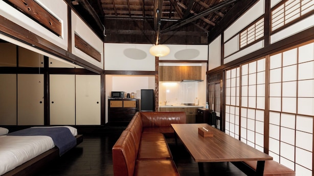 Una habitación tradicional japonesa con suelo de tatami, una mesa de madera baja y un banco empotrado.