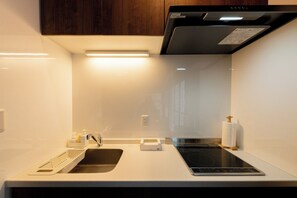 A modern kitchen with a built-in oven, a sink, and a countertop. - Kohaku Amber Kamakura Zaimokuza (Kamakura)