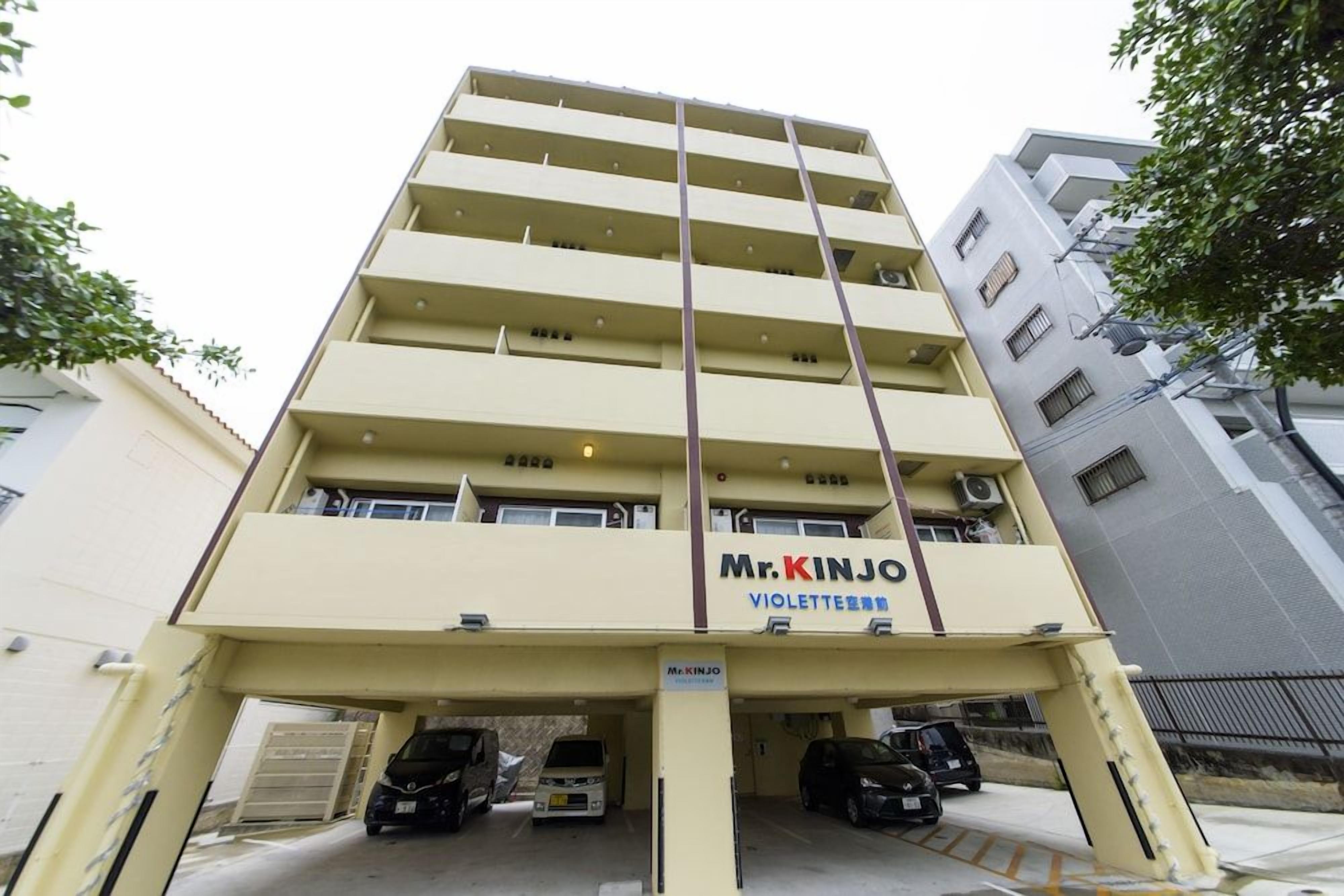 Un edificio a più piani con un cartello che riporta la scritta 'Mr. KINJO VIOLETTE HOTEL'.