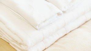 A stack of neatly folded white towels. - Mr. Kinjo Violette Kukomae (Naha)