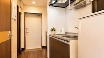 A compact kitchen with a refrigerator, stove, and sink.