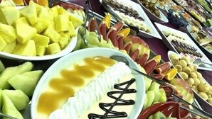 Un bufé con diversas frutas y postres.