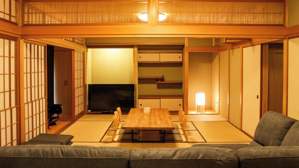 A traditional Japanese-style room with tatami flooring, a low table, and a sofa. - Otomari Chuzaemon (Shodoshima)
