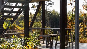 A wooden deck with tables and a ladder, surrounded by trees and foliage. - Secret Break Isumi (Isumi)