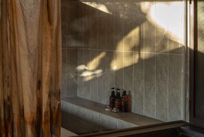 A bathroom with a marble wall and a bench. There are bottles on the bench. - Secret Break Isumi (Isumi)