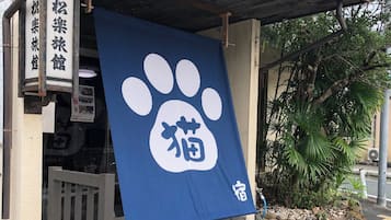 A building entrance with a blue banner featuring a white paw print and Japanese characters.