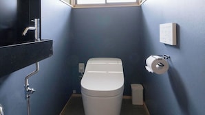 Ein kleines Badezimmer mit Toilette, Waschbecken und Fenster.