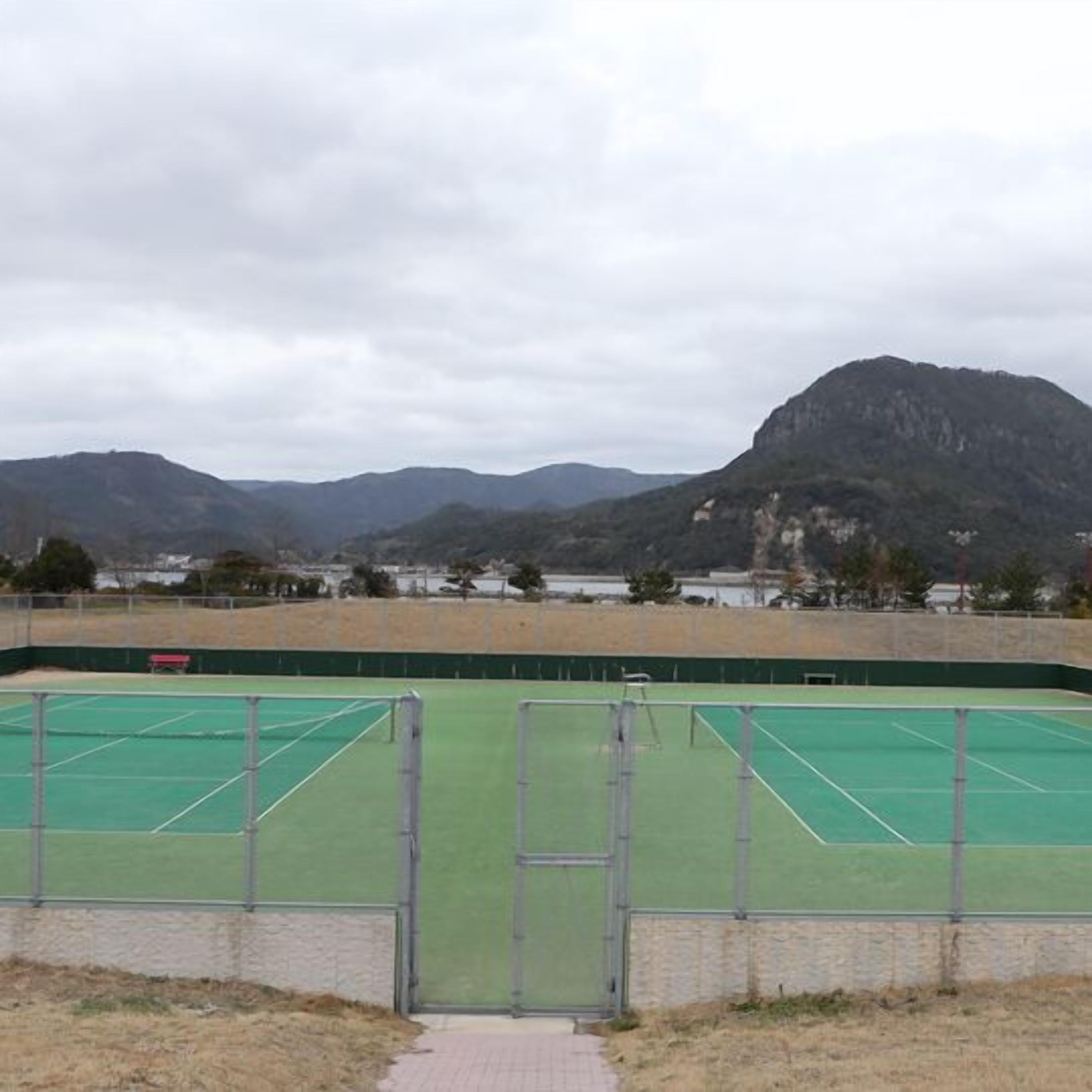 A tennis court with a view of mountains in the background.
