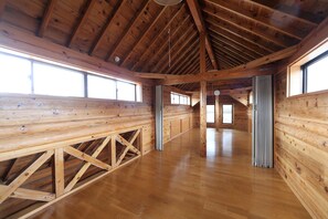 Una cabaña de madera espaciosa con techos altos y ventanas grandes.