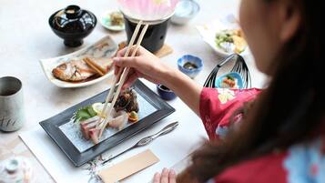 A dining table with various dishes, chopsticks, and a teapot.