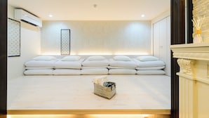 A modern room with a large bed, a wall-mounted air conditioner, and a framed picture on the wall. - Guest Villa Hakone Yumoto (Hakone)