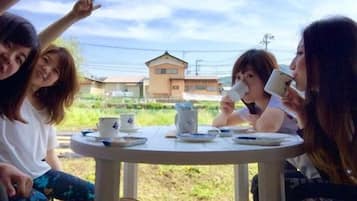 A group of people sitting around a round table outdoors with a building in the background.